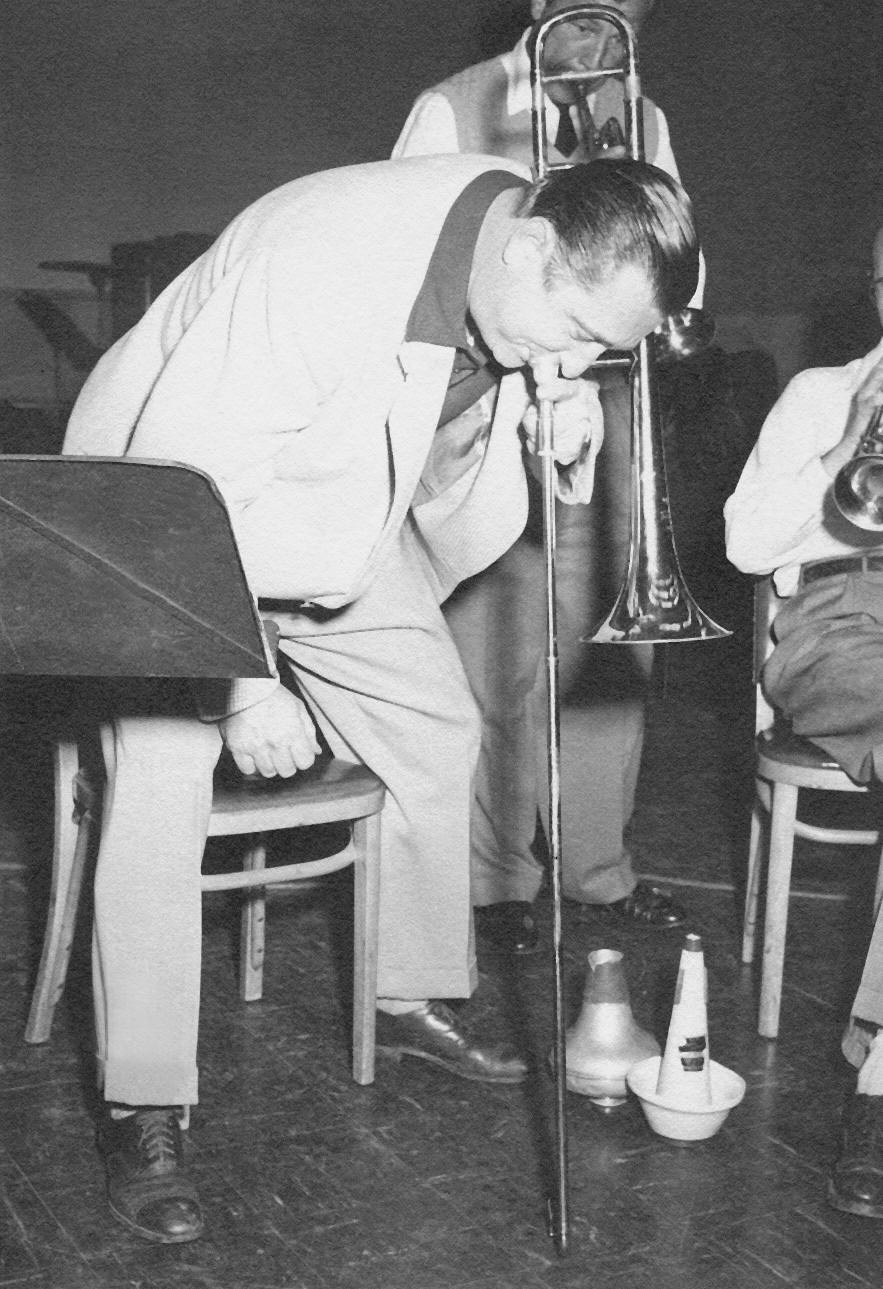 Abe playing horn with slide on floor